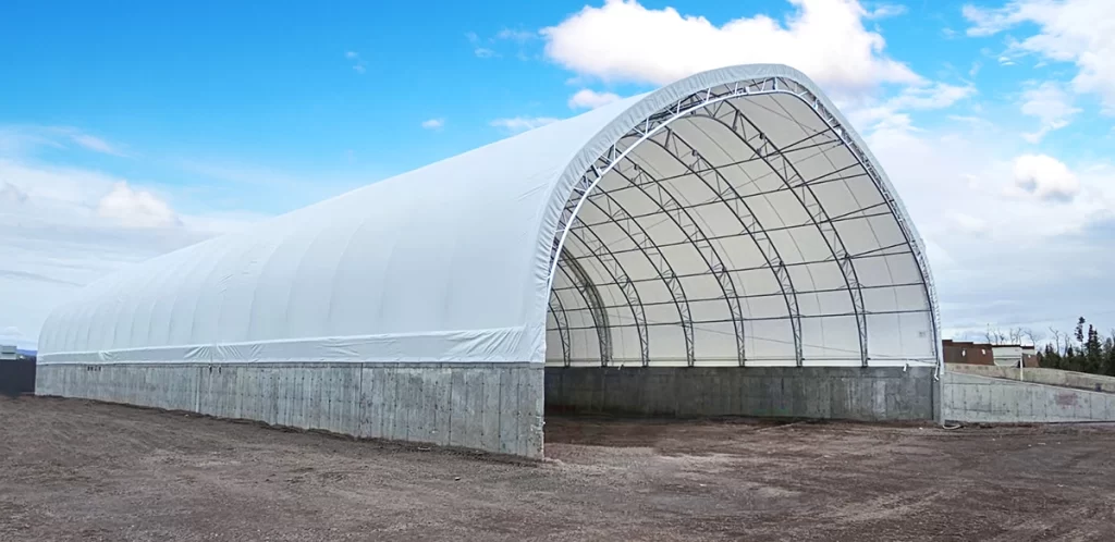 Completed steel structure, industrial-grade building, flexible membrane, cost-saving solution, Permodome expertise. Structure en acier terminée, bâtiment de qualité industrielle, membrane flexible, solution économique, expertise Permodome.