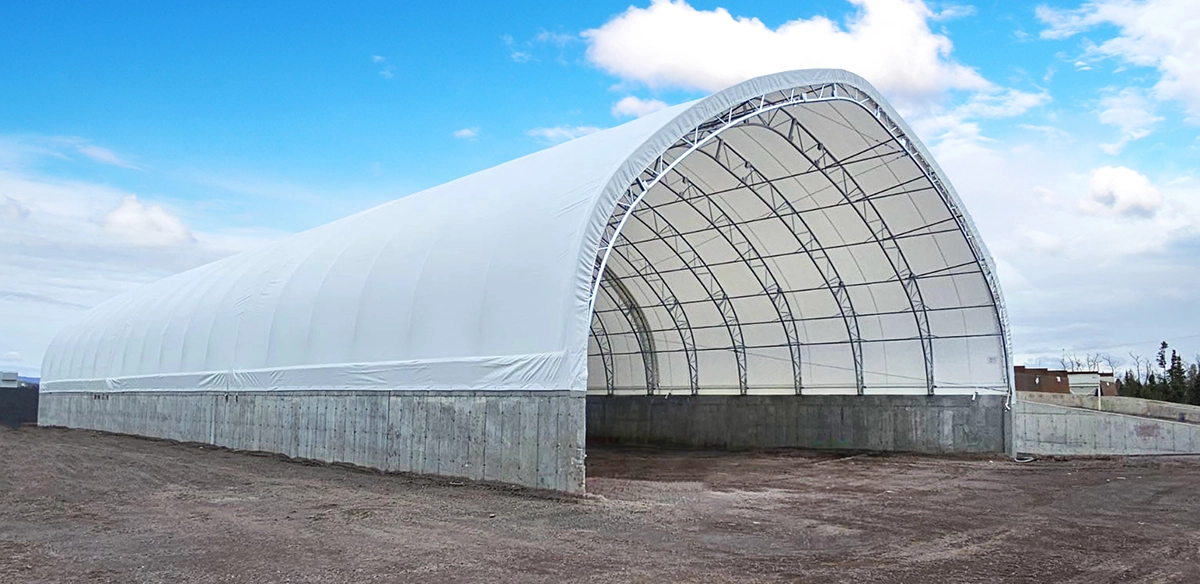 Completed steel structure, industrial-grade building, flexible membrane, cost-saving solution, Permodome expertise. Structure en acier terminée, bâtiment de qualité industrielle, membrane flexible, solution économique, expertise Permodome.
